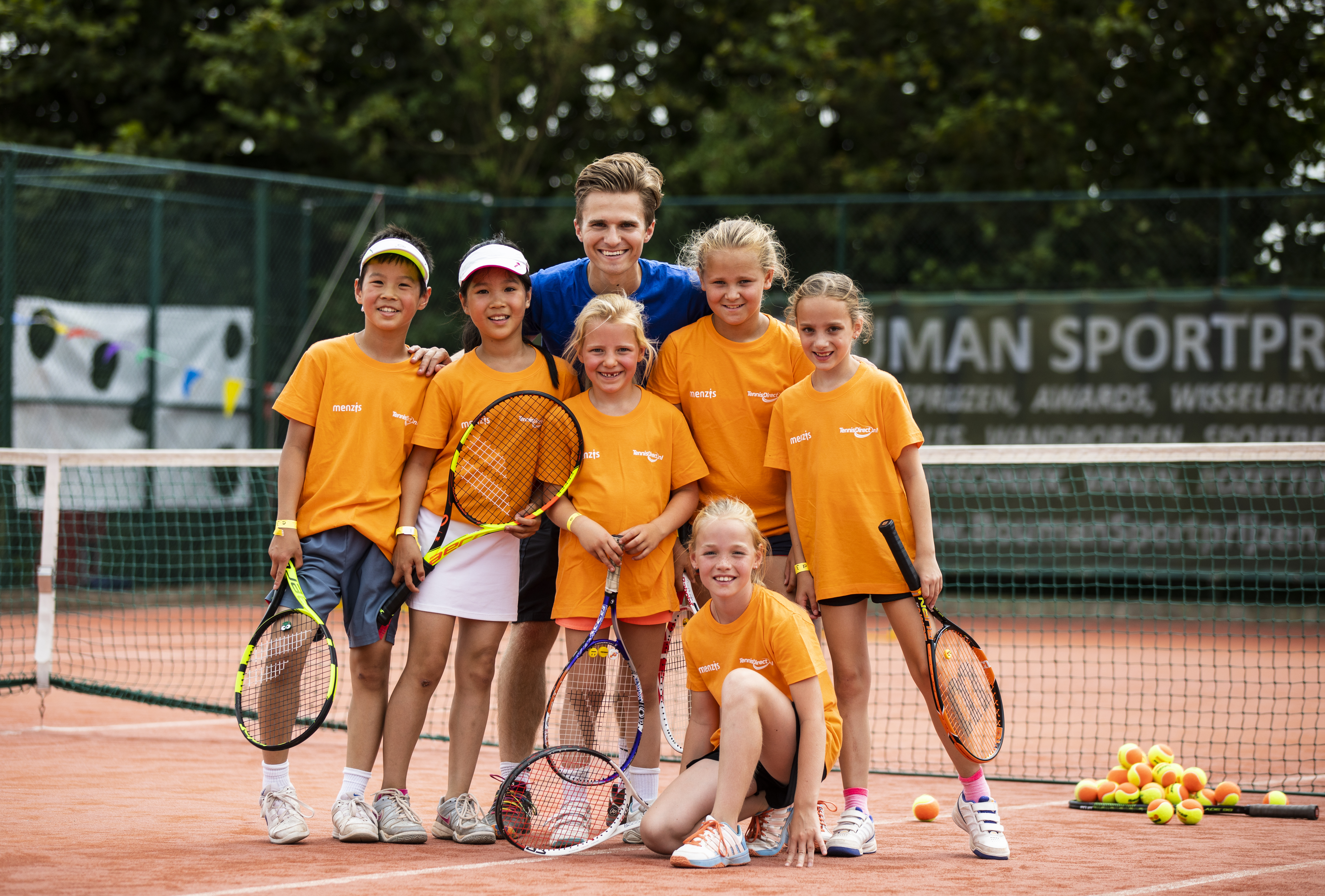 Kinderen met tennisleraar