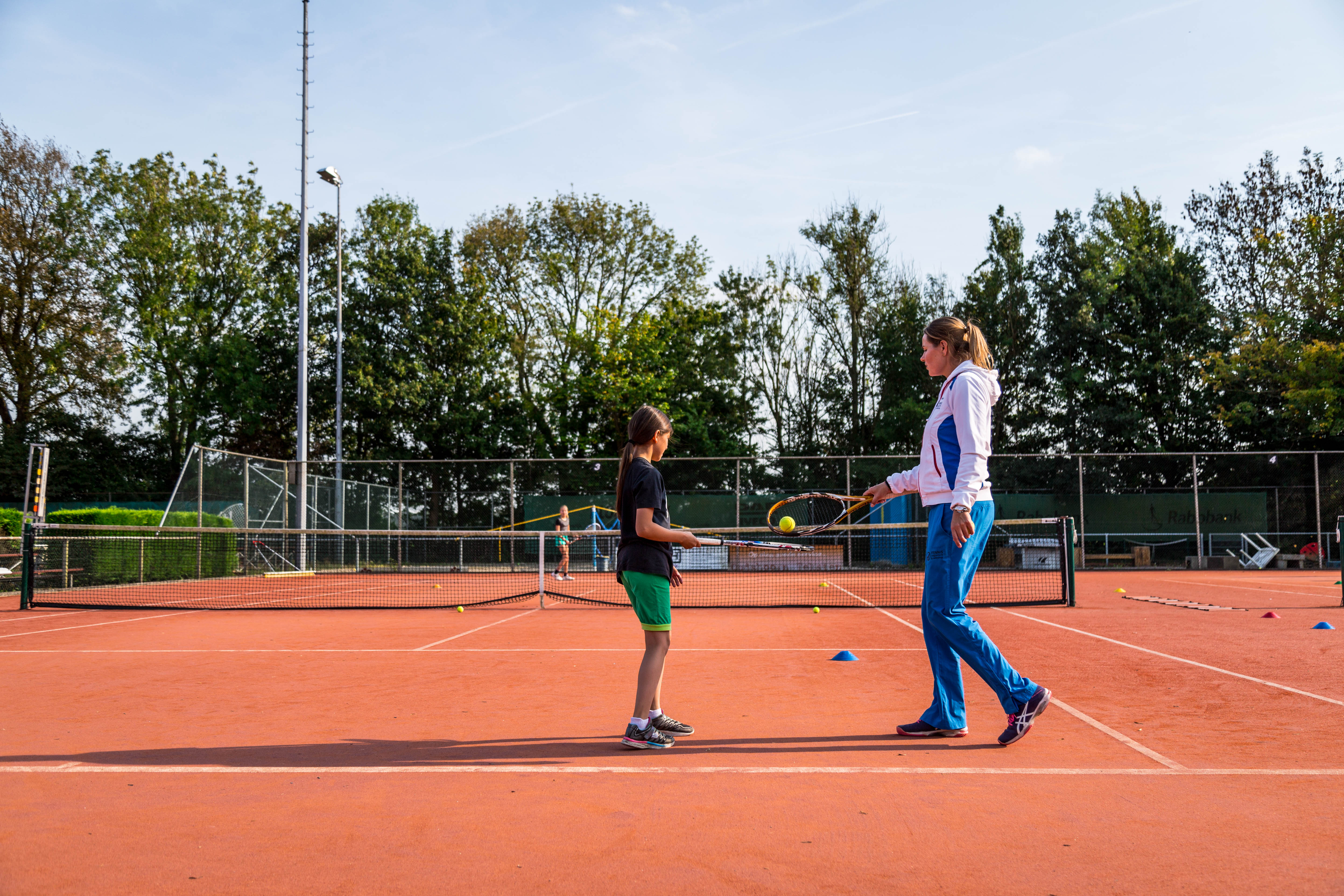 Tennisles leraar met kind